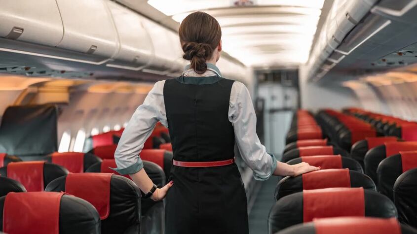 Una azafata de vuelo supervisando el avión.