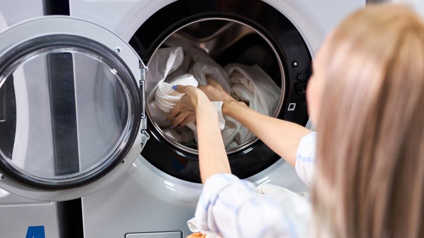 Una mujer poniendo la lavadora.